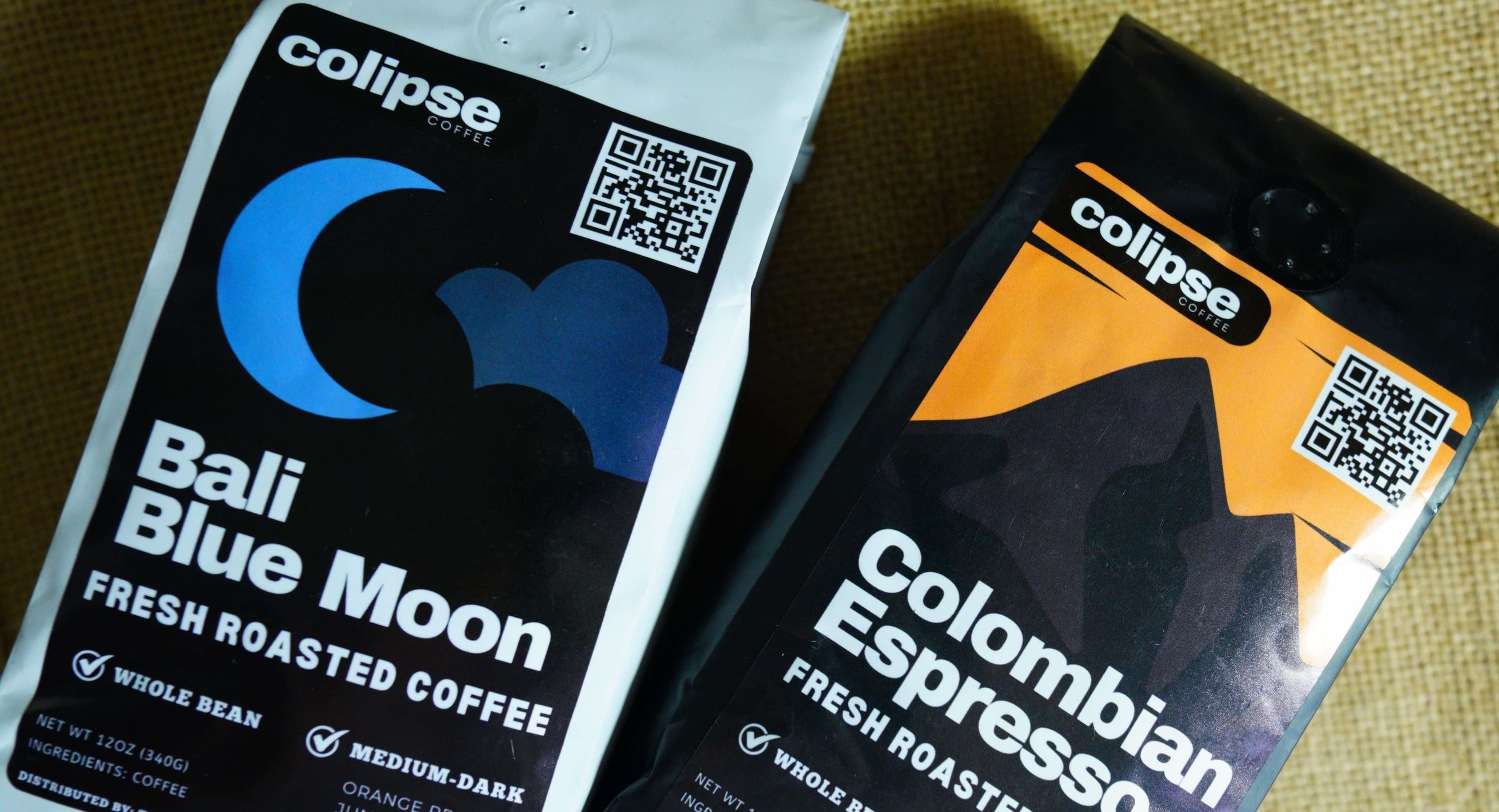 Two packages of Colipse coffee, one labeled 'Bali Blue Moon' and the other 'Colombian Espresso', on a textured surface.