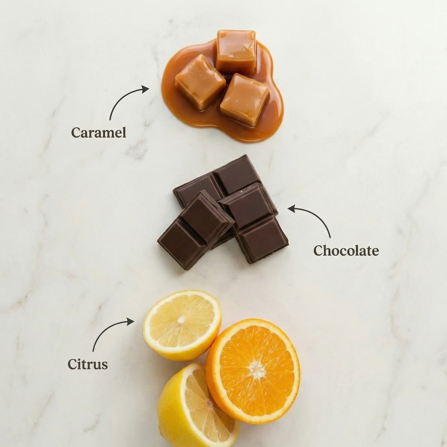 Caramel, chocolate, and citrus fruits on a marble surface with labels indicating their names.