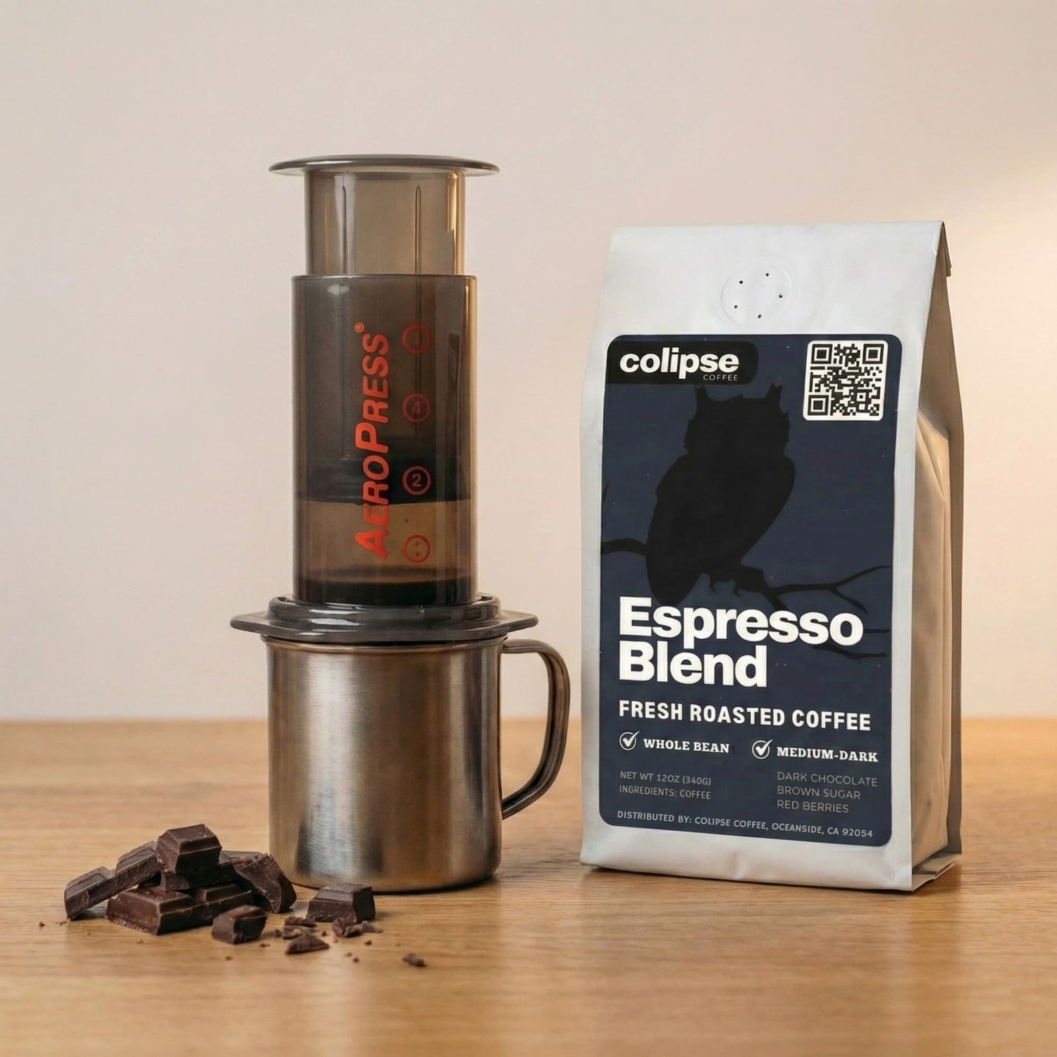 AeroPress coffee maker and Colipse Espresso Blend coffee bag on a wooden surface.