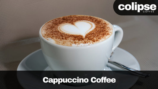 Cappuccino coffee with a heart foam art on top, served in a white cup with a saucer, featuring the Colipse Coffee brand.