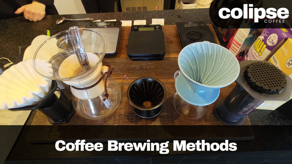 Coffee brewing methods demonstration on a wooden counter with various coffee brewing equipment.