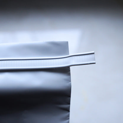 Close-up of a coffee bag tin-tie closure used to fold and reseal the top of the bag.