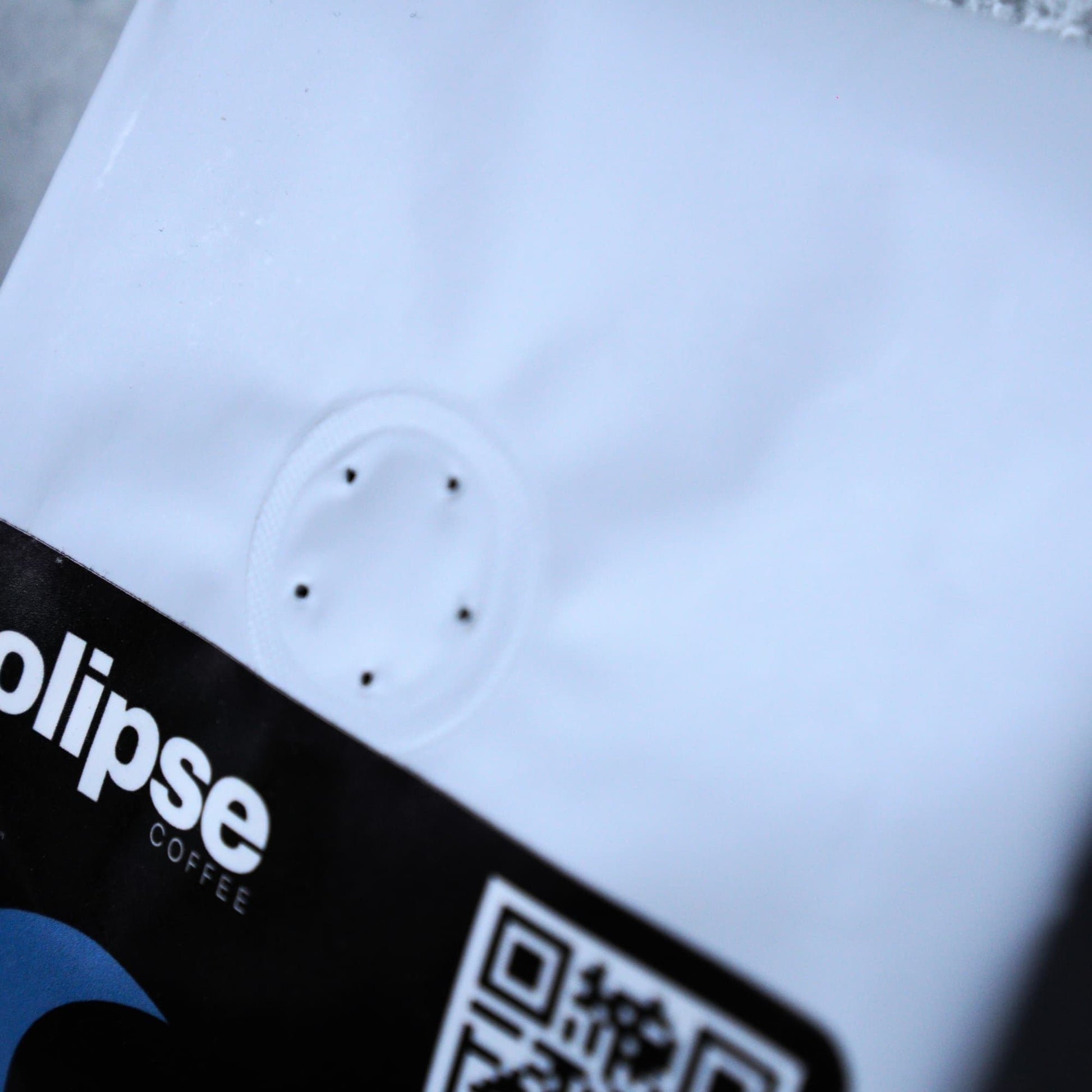 Close-up of a coffee package with 'Colipse' branding and a QR code.