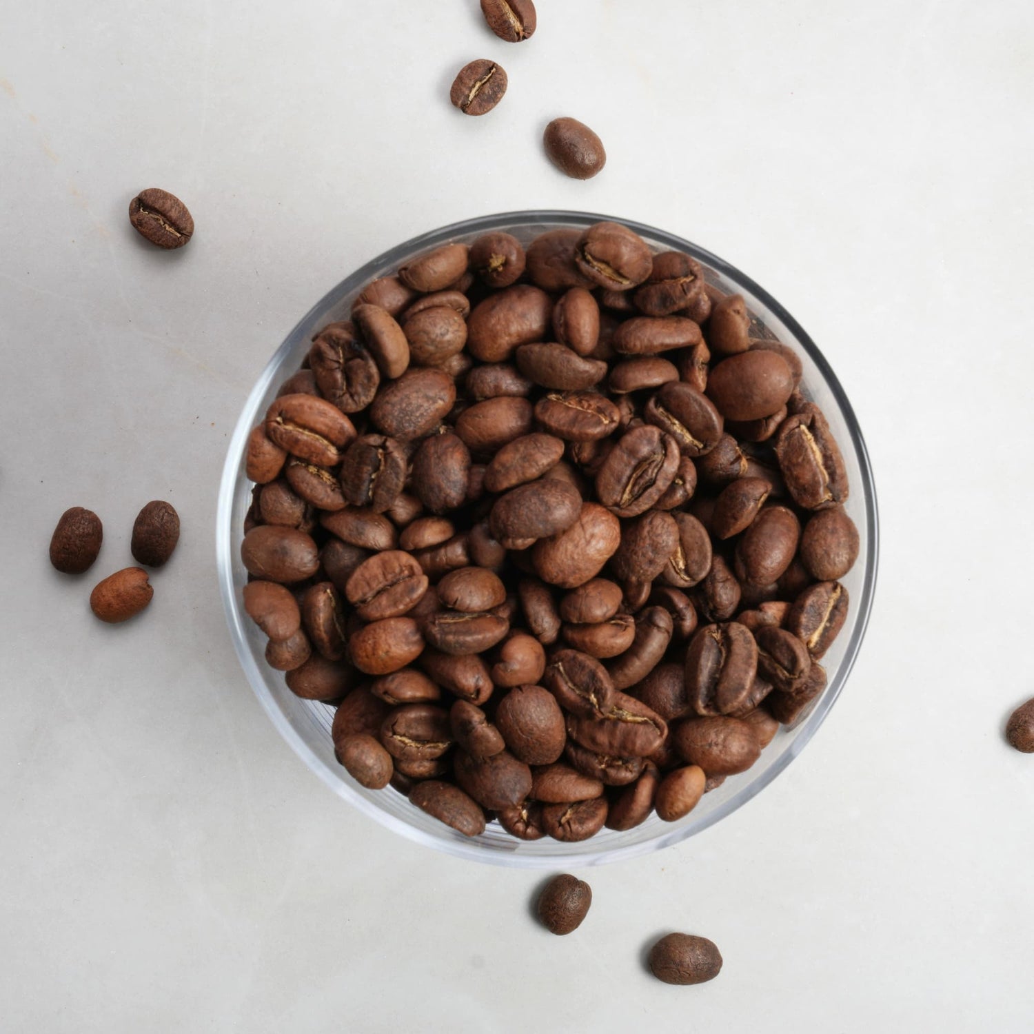 Coffee beans in a glass bowl on a light background