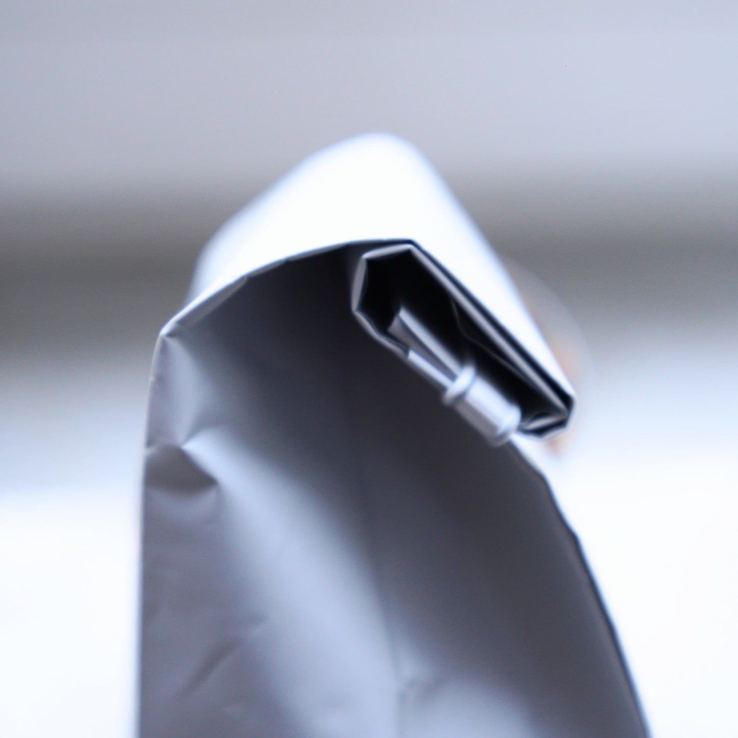 Close-up of a white coffee bag with a blurred background