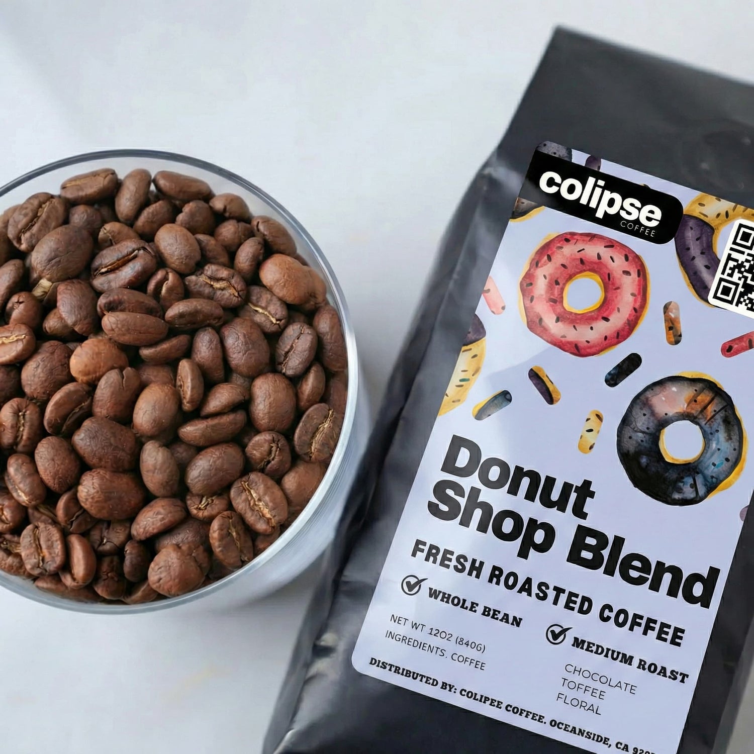 Colipse Donut Shop Blend coffee package with a bowl of coffee beans on a white background