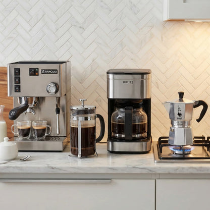 Collection of coffee-making devices on a kitchen counter with a tiled backsplash.