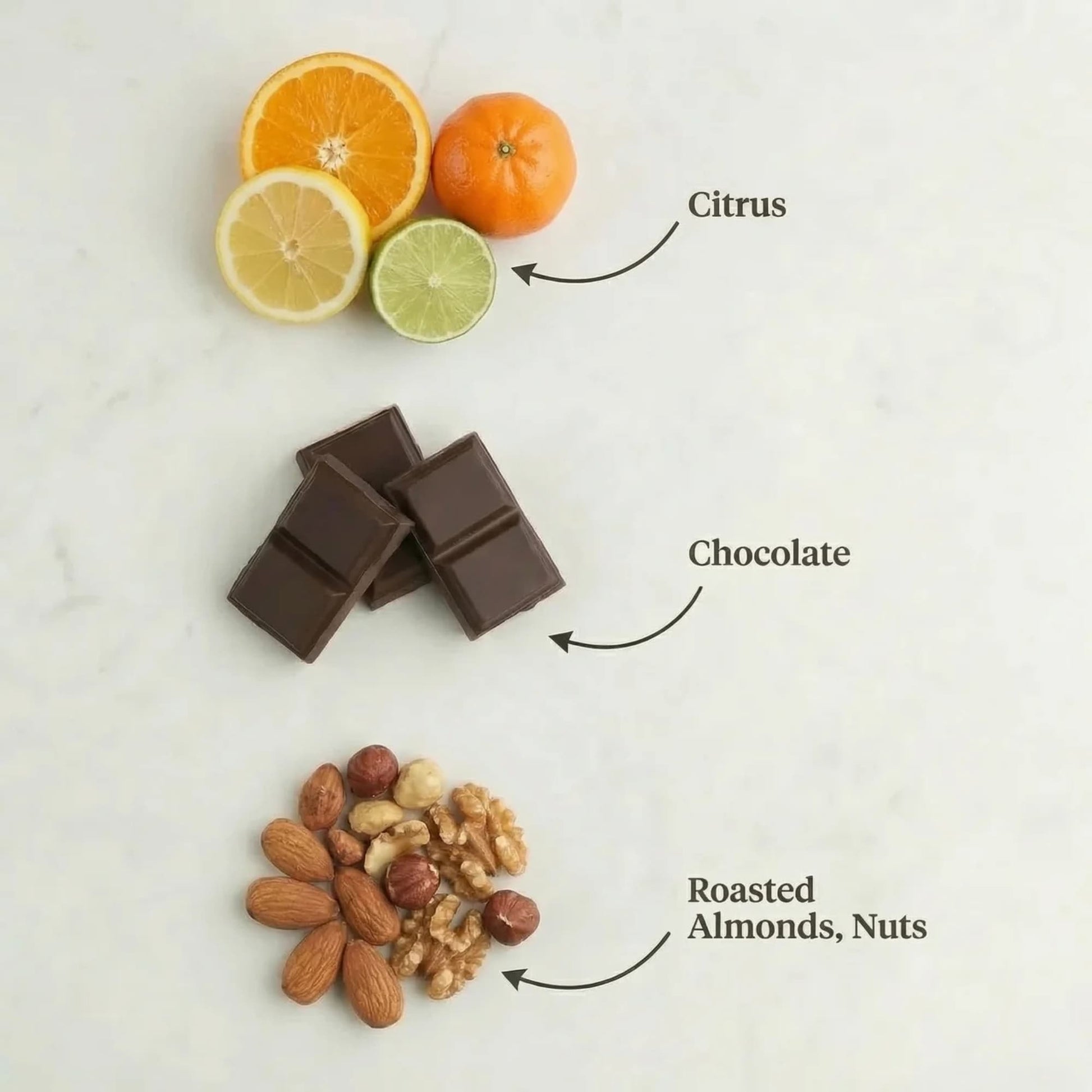 Chocolate bars, citrus fruits, and roasted almonds on a light background