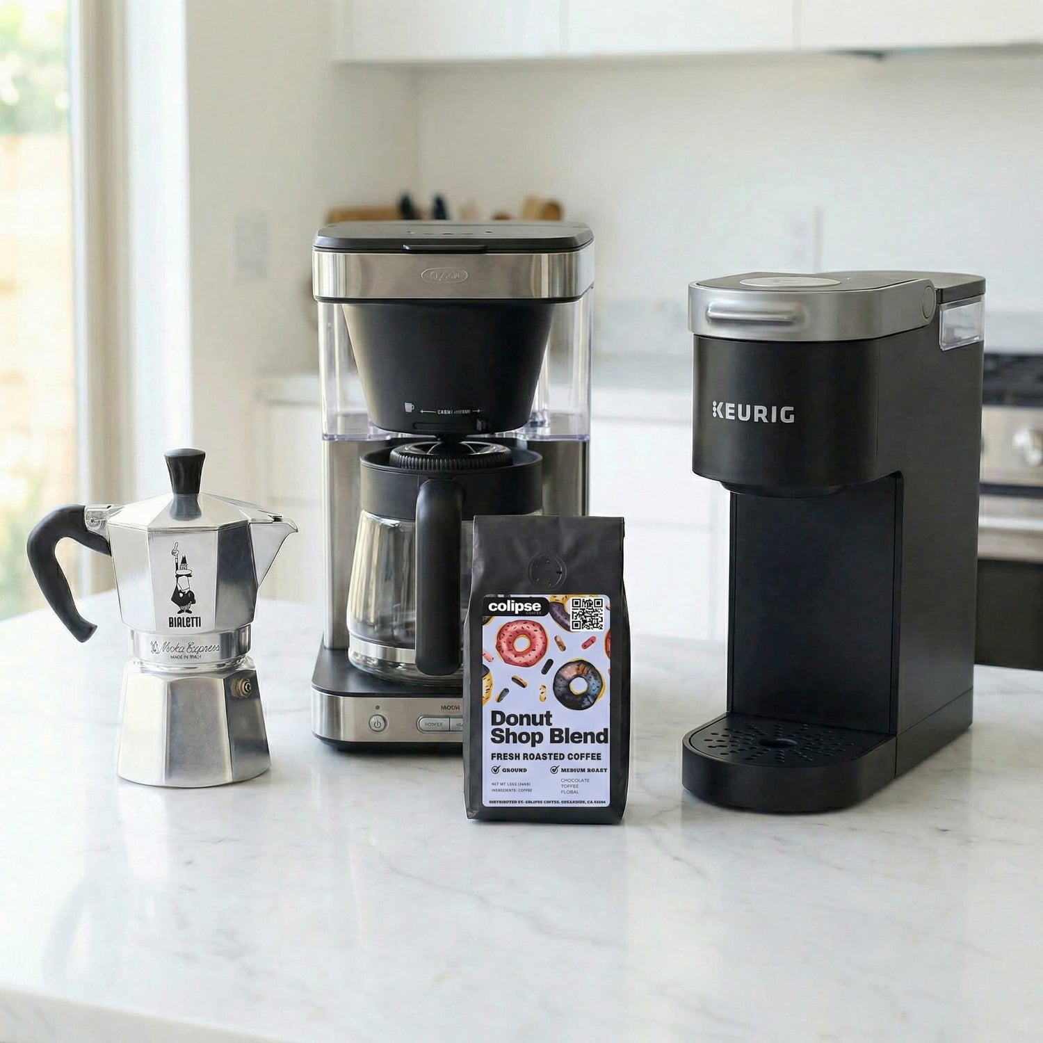 Coffee-making equipment including a Moka pot, coffee grinder, and Keurig machine on a kitchen counter.