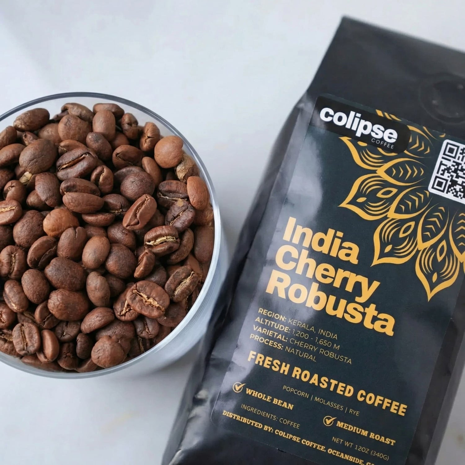 Colipse India Cherry Robusta coffee package with a bowl of coffee beans on a white background