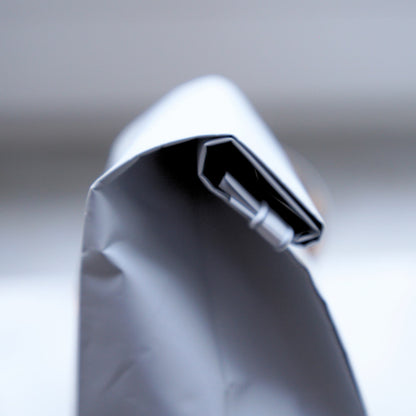 Close-up of a metallic coffee bag zipper  with a blurred background